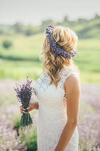 新娘拿着花束在紫衣草地上图片