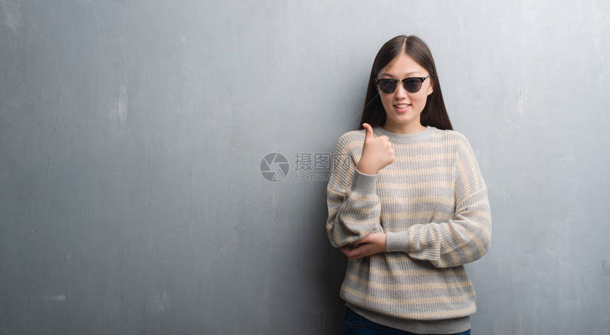 身穿墨镜的白墙上年轻女子快乐地笑着微笑做好牌子图片