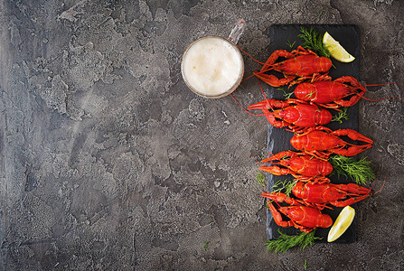 啤酒杯和红煮的龙虾鱼上装着柠檬片最顶端风图片