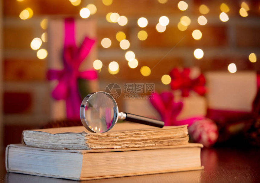 放大镜和关于童话灯光和礼物背景的书籍图片