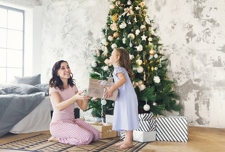母亲和小孩在圣诞树附近玩得开心图片