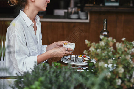 年轻女子在餐厅端着咖啡的镜头图片