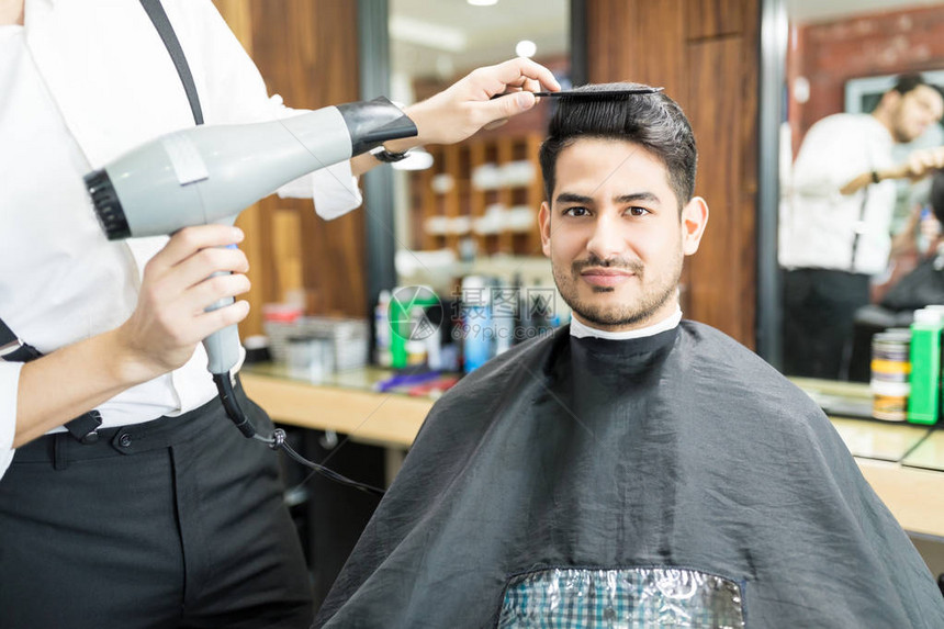 理发师在美发店用理发机清洗客户图片
