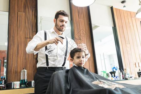 年轻男理发师在理发店的顾图片