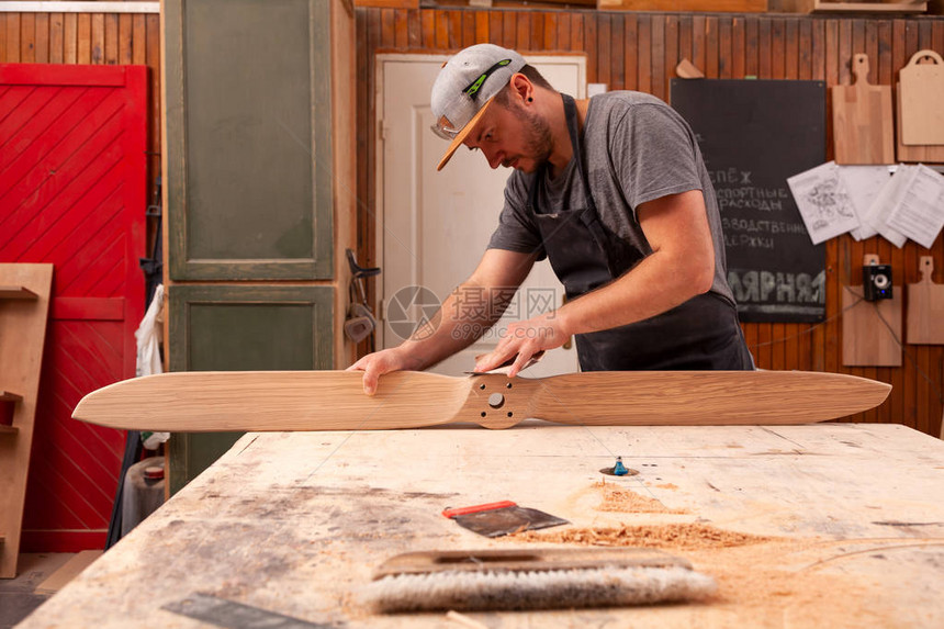 经验丰富的穿工作服的木匠和在木工车间工作的小企业主图片