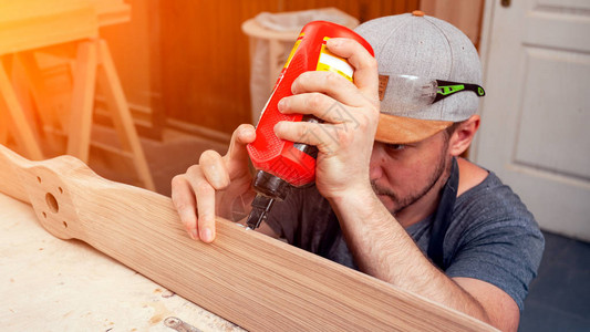 一个年轻人的近身建筑工木匠等于胶水木背景图片