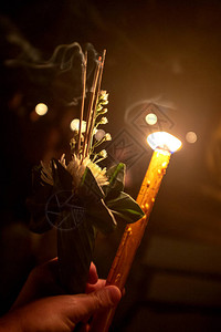 手拿着香花和蜡烛的传统泰国祭品图片