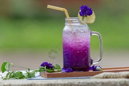 鲜紫蝴蝶梨或蓝豌豆花和柠檬汁在玻璃上绿图片