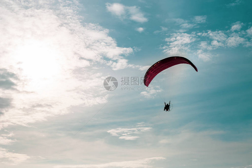 摩托车滑翔伞在蓝天空中飞行图片