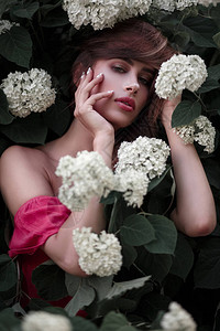 花朵在花园中的美丽年轻女子模特图片