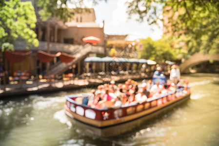 模糊的游客喜欢沿着色彩缤纷的RiverWalk乘坐河船图片