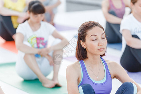 一群快乐可爱的年轻女子在瑜伽中坐着和伸展的瑜伽阿萨纳姿势默思和图片
