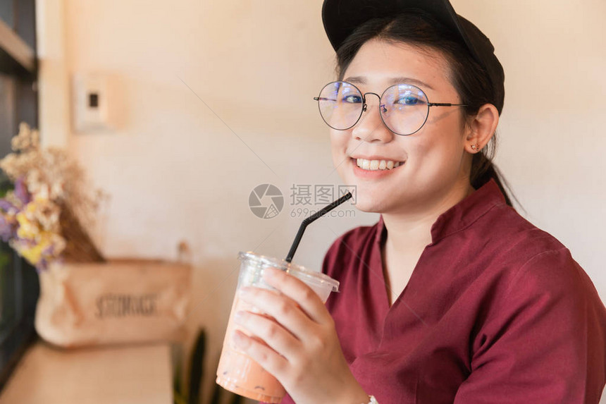 在咖啡馆用稻草喝冰咖啡的少女图片