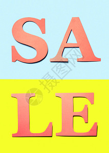 垂直销售标志红色橙字母从浅蓝色和黄色背景的纸板上剪下用于营销特别优惠活动的彩色工艺横幅充满活力的背景