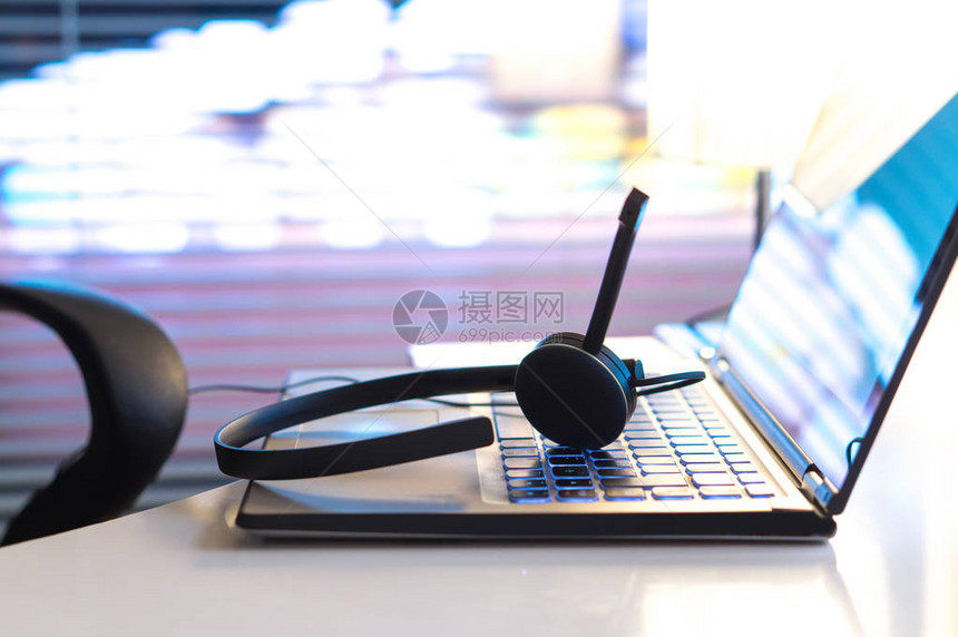 帮助台247客户服务支持热线或呼叫中心概念深夜在办公室的笔记本电脑键盘上的耳机视频电话会图片