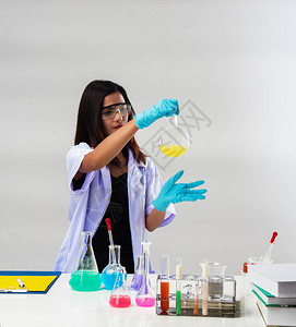 戴防护眼镜的化学家在实验室用试管和试剂工作图片