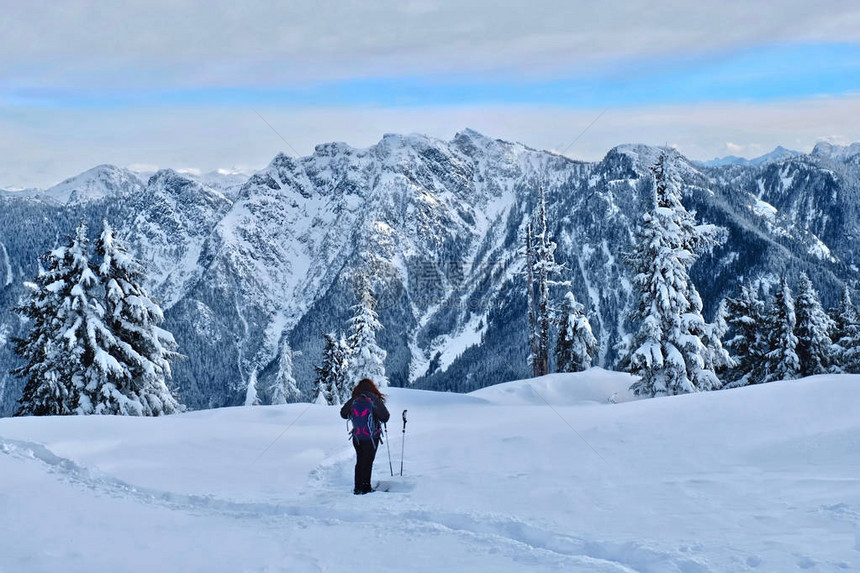 女人在温哥华附近的北岸山区徒步雪鞋行走柏树山滑雪胜地在冬天暴风雪过后图片