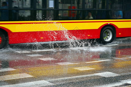 大雨时从公共汽车轮下溅出的水花背景图片