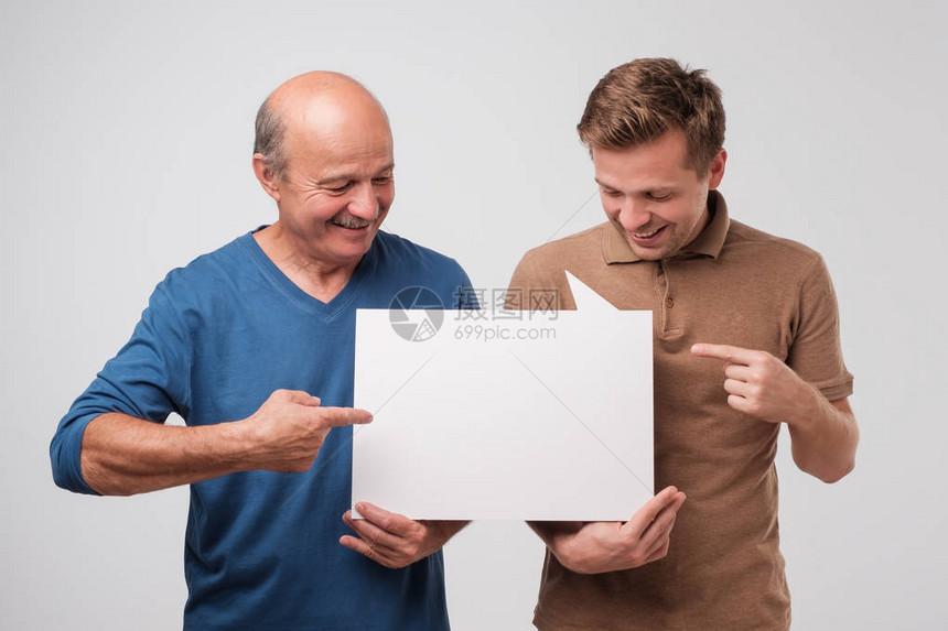 两个成熟的男人父子一起拿着一个白色的空广告牌图片