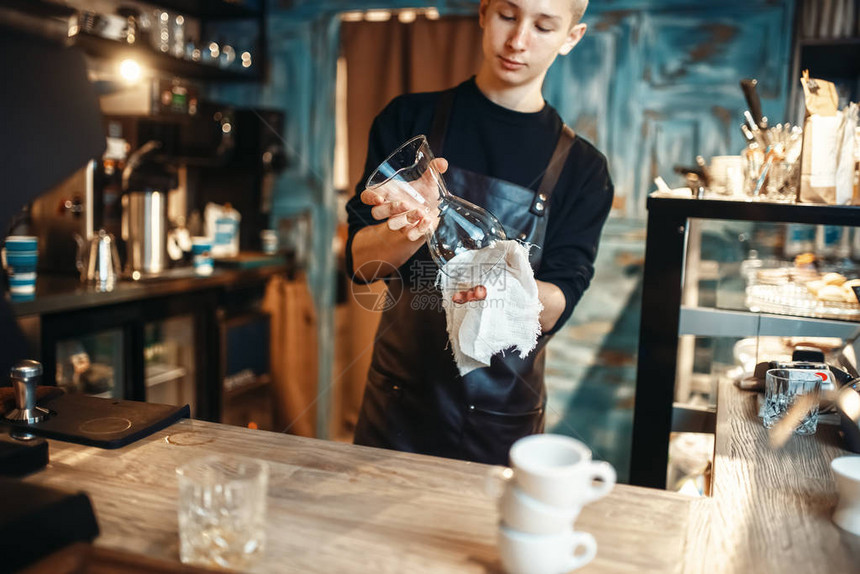 男律师协会青年在咖啡柜台煮咖啡后擦盘子Barman在自助餐厅工作图片