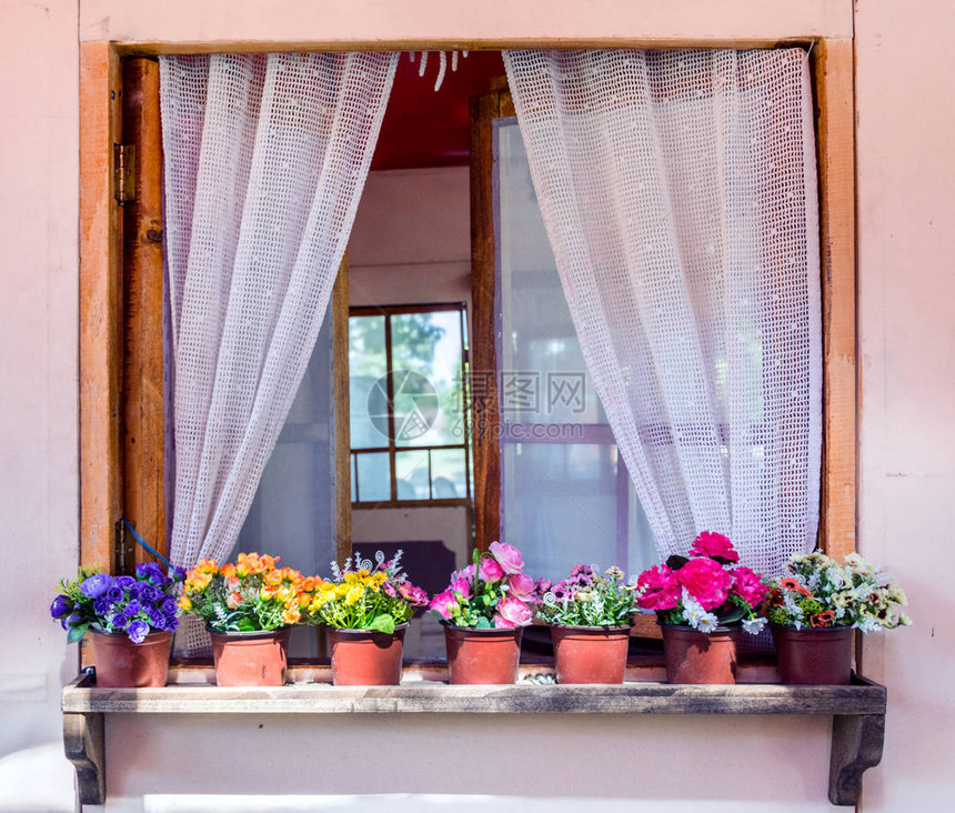 老房子上的花盆里有窗帘的窗户复古和复古的概念特写图片