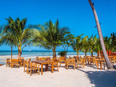 在沙滩和蓝天上坐木桌椅图片