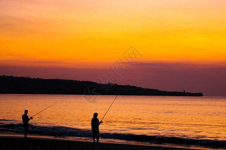 渔民在海滩上的渔棍上钓鱼图片