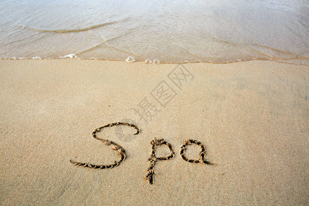 Spa字写在海边的沙子上幸福的概背景图片