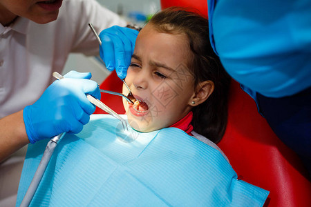 儿童牙科医在办公室治疗将小女孩图片
