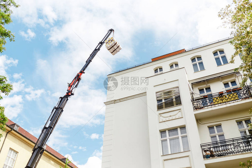 使用起重机吊车修复和恢复建筑物的外墙图片