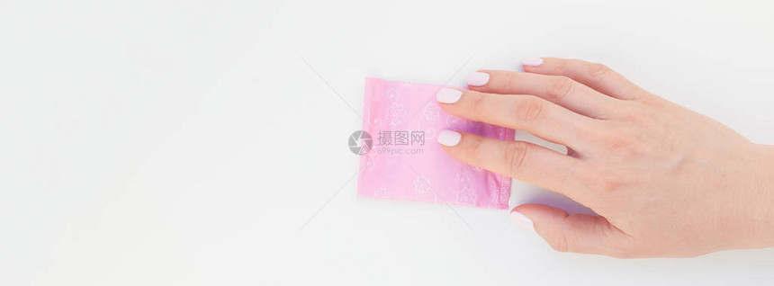 女人手与柔和的修指甲油拿着粉红色的日常卫生巾隔离在白色背景与复制空间女美容博客社交媒体女保健概图片