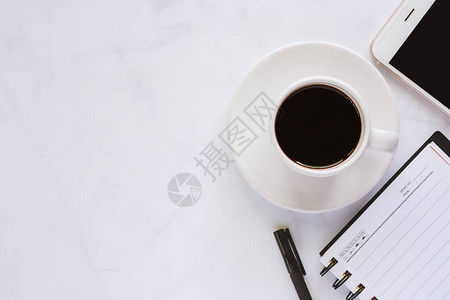 为工作空间概念配备螺旋笔记本笔咖啡杯和白色大理石背景智能手机图片
