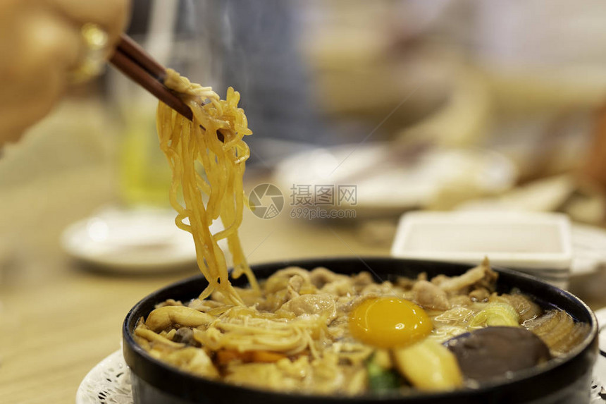 手用筷子吃日本乌冬面和鸡蛋图片