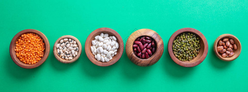 健康的饮食概念木碗中的豆类以绿色背景孤立顶端的视野图片