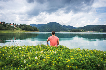 一个人独自坐在塞尔维亚Zaovine湖的大自然中静坐和冥想图片