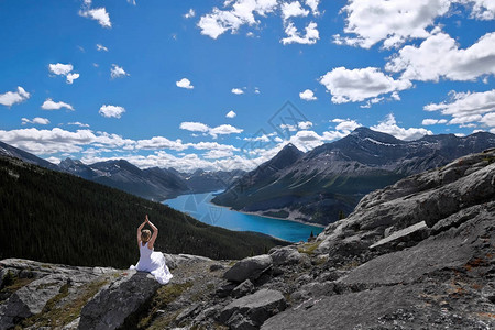 正念和内心的平静在蓝色湖上方的山峰上冥想喷雾湖和加拿大落基山脉的风景西风塔坎莫尔艾伯图片