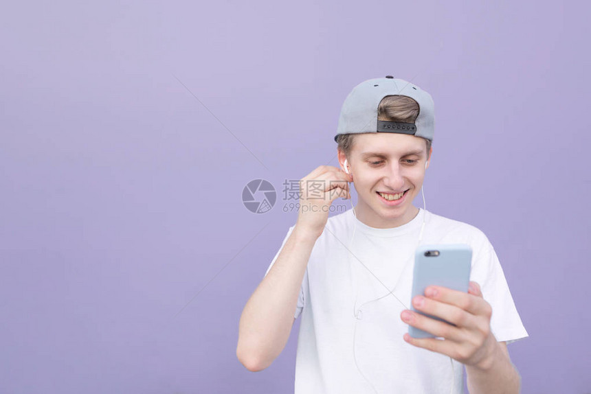 穿着白色T恤的快乐年轻人戴着耳机听音乐图片