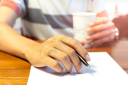 男手握笔在木制图片