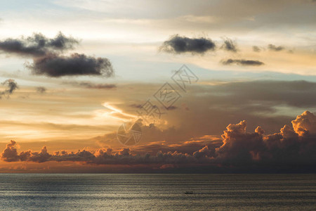 令人惊异的阴云笼罩的日落天空在海上与巴图片
