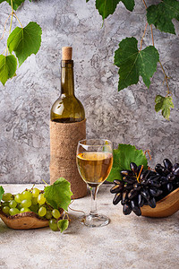 葡萄瓶和杯白葡萄酒图片
