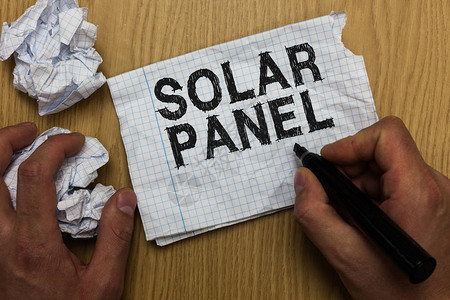 显示太阳能电池板的书写笔记商业照片展示旨在吸收太阳射线产生能量的人拿着记号笔记本纸皱巴背景图片