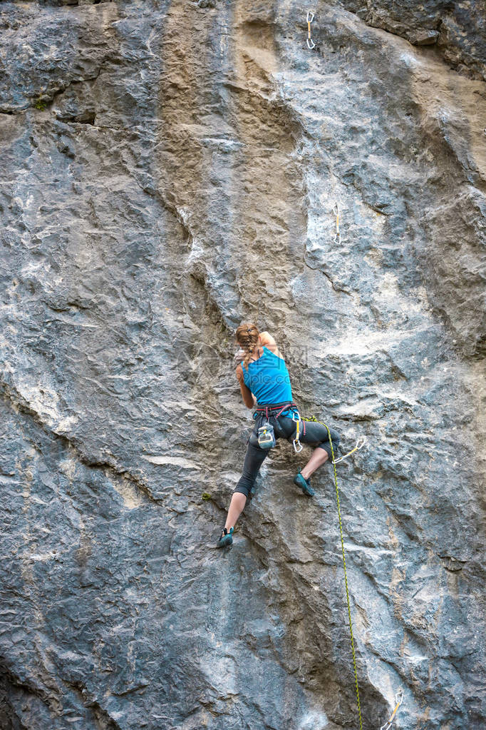 女孩爬上岩石登山者正在训练攀登岩石强壮的运动员克服困难的攀登路线极端的爱好一个女人参加大自然的运动图片