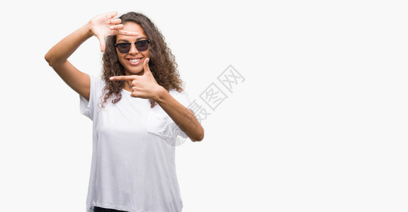 带着太阳镜的年轻西班牙女青年微笑着用手和指做架子图片