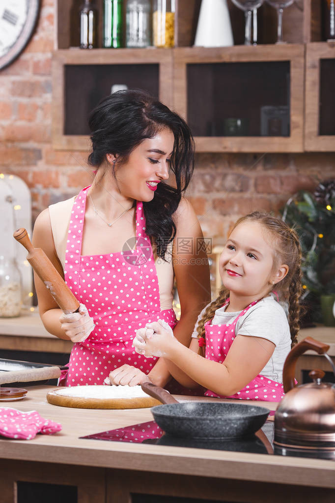 年轻美丽的母亲和女儿一起在厨房做饭图片