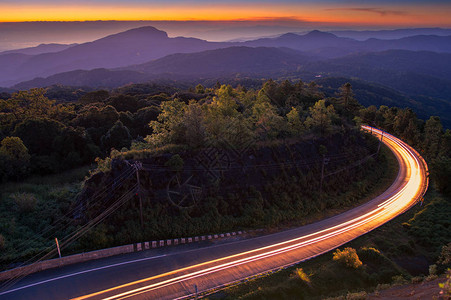 美丽的夕阳天空和云在山与雾和主要道路泰国清迈的茵图片