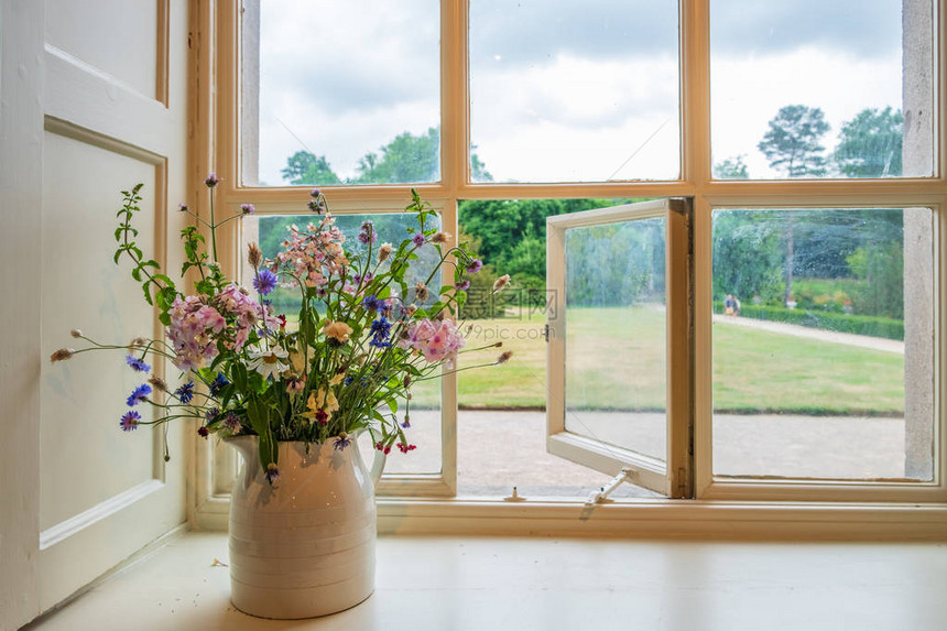 美丽的花朵和窗外风景从传统的英国式图片