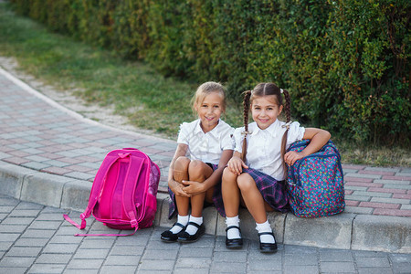 小学生在户外建筑附近背包的女孩开始上课首日秋天图片