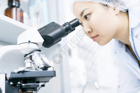 年轻亚洲妇女在医学实验室进行研究时图片