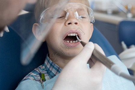 坐在牙椅上的可爱小男孩的肖像牙齿治疗图片