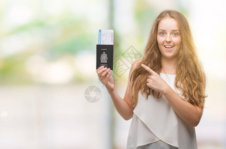 持有卡达护照和登机证的金发年轻金发女青年图片